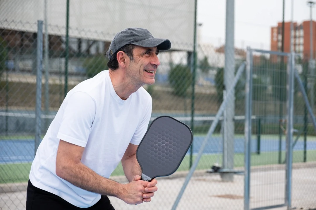 Pickleball Player in Athletic Ready Position on Outdoor Tournament Court